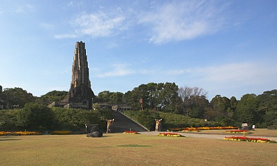 A landscape view of Heiwadai Park featuring the Peace Tower surrounded by greenery and vibrant flower beds.