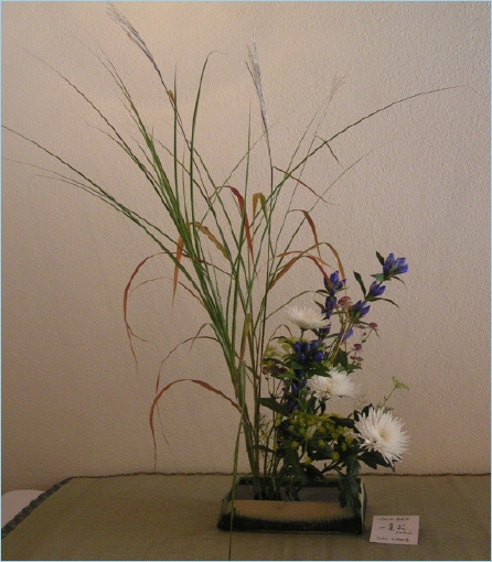 An Ikebana arrangement featuring various flowers and grasses, highlighting the art of Japanese floral design.