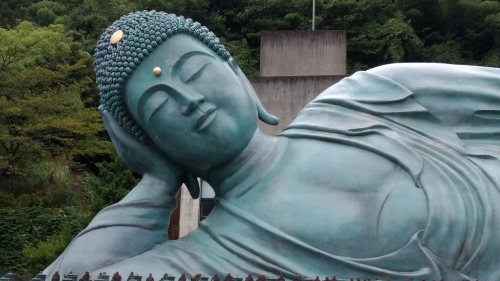 Reclining Buddha statue at Nanzoin temple, showcasing serene facial expression and intricate details.