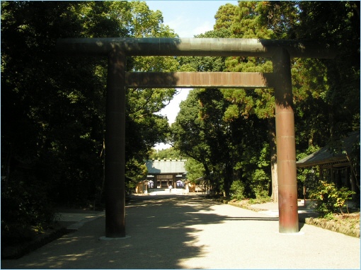A large torii gate leading to Miyazaki Jingu Shrine, surrounded by dense greenery.