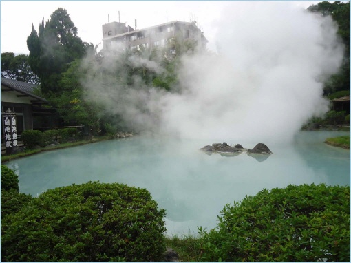A scenic view of a geothermal pool with steam rising from the water, surrounded by lush greenery and rock formations.